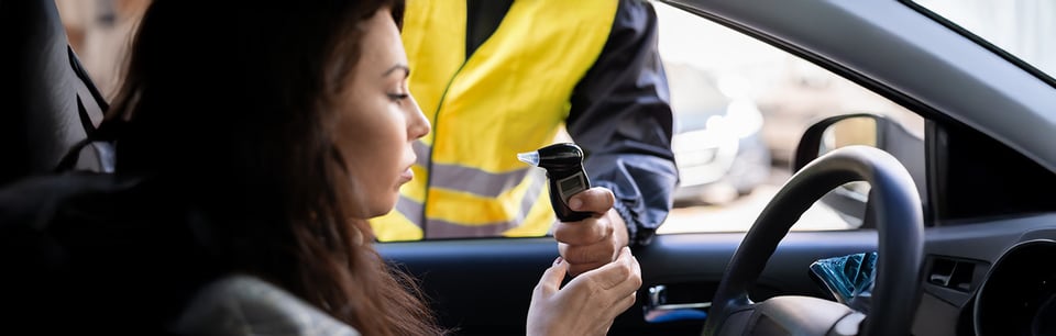 Prueba de alcoholímetro a individuo que se conduce en un vehículo.